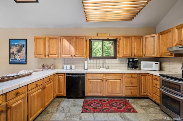 2246 Gcr 8, Fraser, CO 80442 - kitchen with black dishwasher, range with two ovens, white microwave, under cabinet range hood, and decorative backsplash