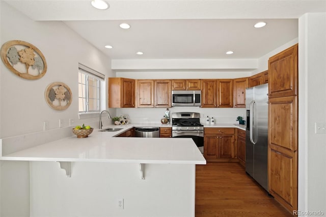 kitchen with stainless steel appliances, a kitchen bar, and kitchen peninsula