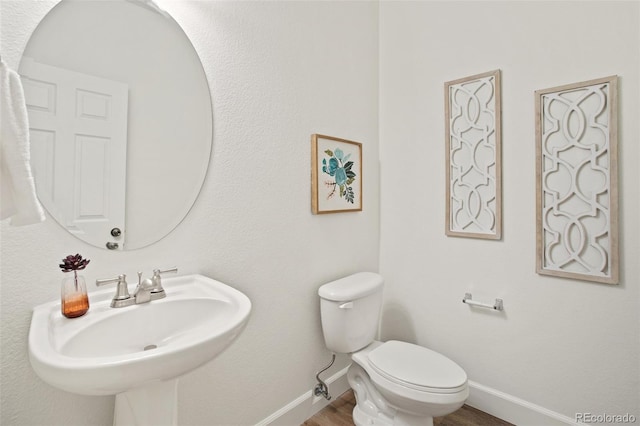 bathroom with sink, hardwood / wood-style floors, and toilet