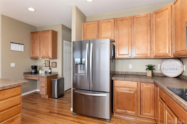 kitchen with stainless steel fridge with ice dispenser, light wood-style floors, and recessed lighting