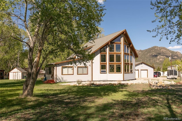 426 S San Juan Ave, Buena Vista, CO 81211 - rear view of property featuring entry steps, a yard, a mountain view, and a garage