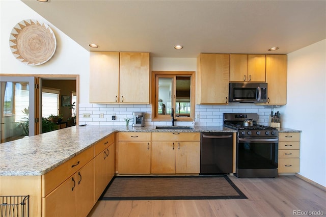 426 S San Juan Ave, Buena Vista, CO 81211 - kitchen featuring appliances with stainless steel finishes, a sink, light brown cabinets, light wood-style floors, and a peninsula