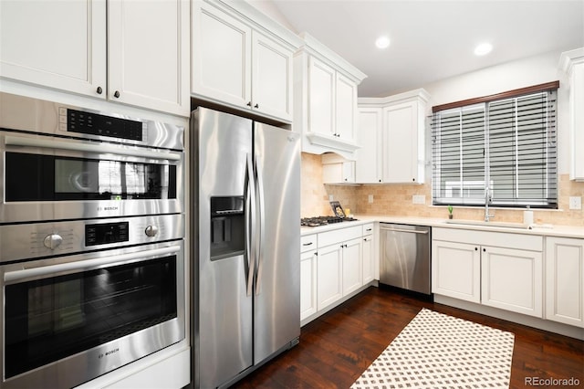 3320 Yukon Ct, Wheat Ridge, CO 80033 - kitchen with stainless steel appliances, light countertops, decorative backsplash, white cabinetry, and dark wood-type flooring