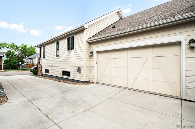 3320 Yukon Ct, Wheat Ridge, CO 80033 - view of side of home featuring concrete driveway, roof with shingles, and a garage