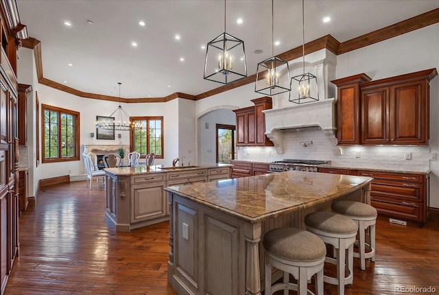 kitchen featuring stove, decorative backsplash, decorative light fixtures, and a center island