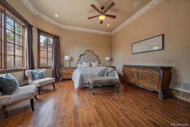 bedroom featuring visible vents, ceiling fan, ornamental molding, and hardwood / wood-style flooring