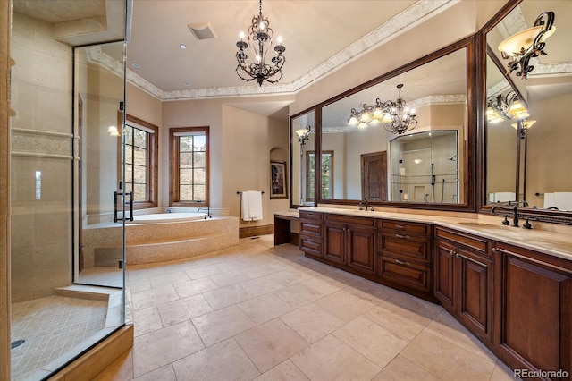 full bathroom with a stall shower, a garden tub, a sink, and a notable chandelier