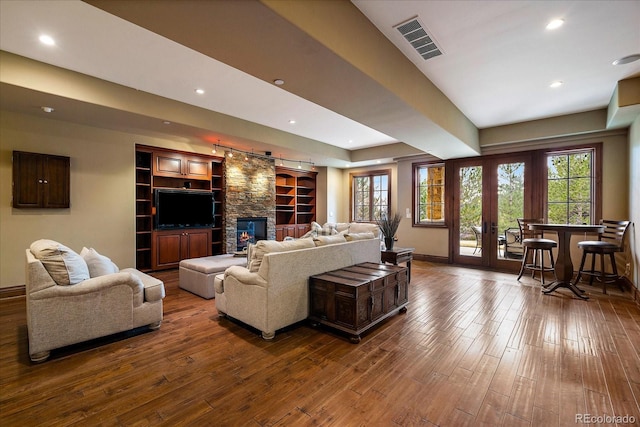 living area with visible vents, plenty of natural light, and hardwood / wood-style floors