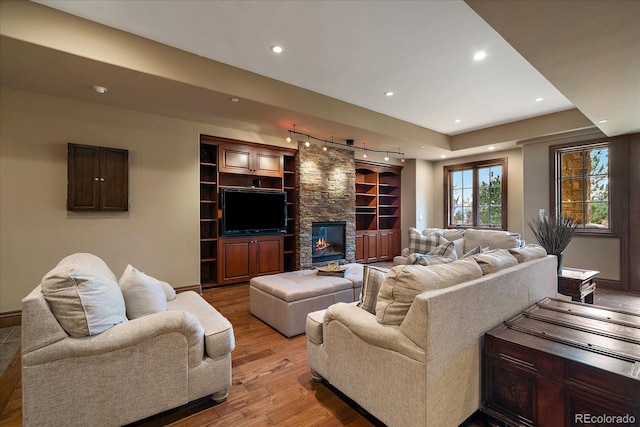 living area with light wood-type flooring, a fireplace, baseboards, and recessed lighting