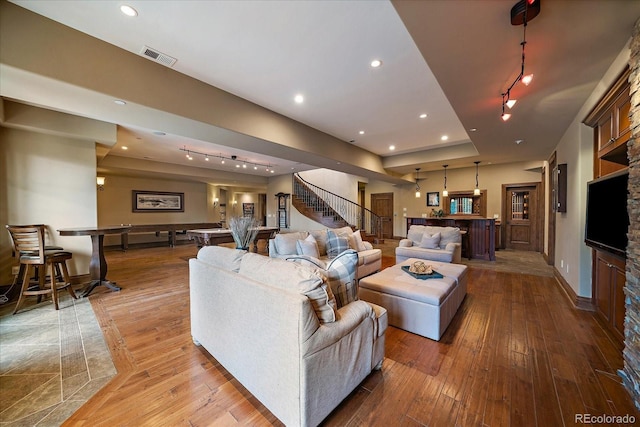 living room with recessed lighting, visible vents, light wood-type flooring, baseboards, and stairs