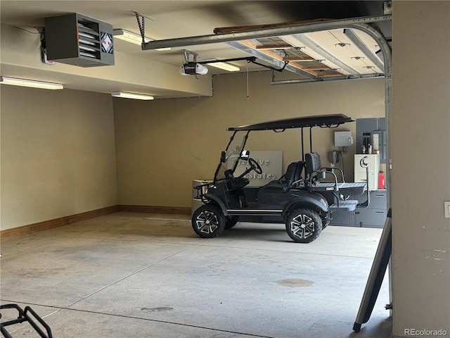 garage with baseboards, a heating unit, and a garage door opener