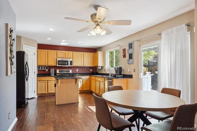 13818 Krameria St, Thornton, CO 80602 - kitchen featuring a center island, a ceiling fan, dark countertops, stainless steel appliances, and dark wood-style floors