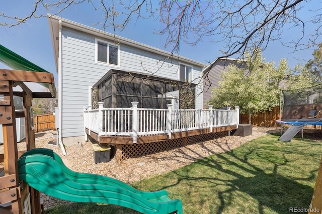 13818 Krameria St, Thornton, CO 80602 - back of property featuring a lawn, a trampoline, a deck, and fence private yard