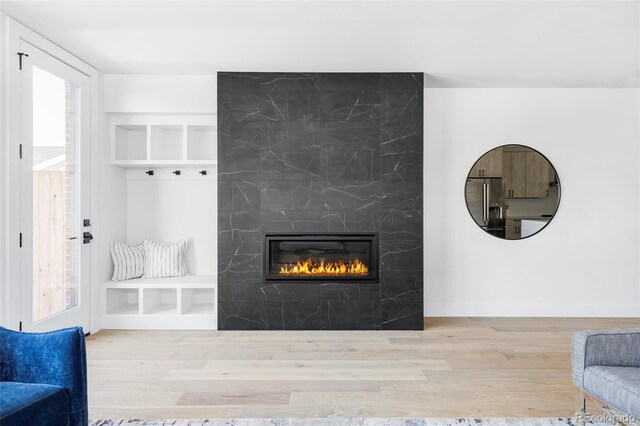 living room with a fireplace, wood finished floors, and baseboards