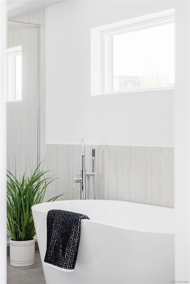 full bathroom featuring a soaking tub and tile patterned floors