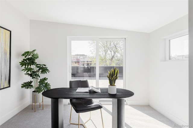 office area with light carpet, vaulted ceiling, and baseboards