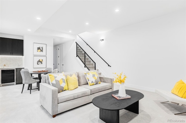 living area featuring stairway, recessed lighting, light colored carpet, and beverage cooler