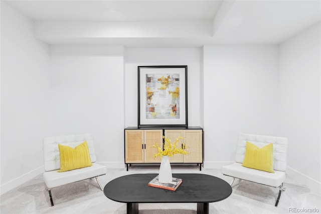 sitting room featuring carpet and baseboards
