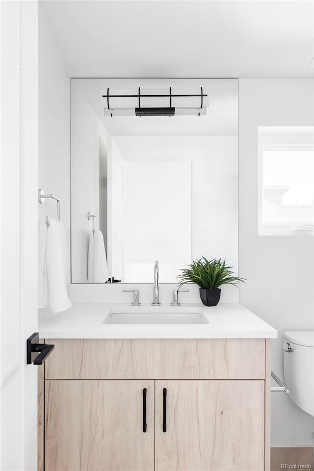 bathroom featuring vanity and toilet