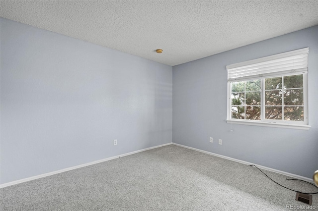 carpeted empty room featuring a textured ceiling