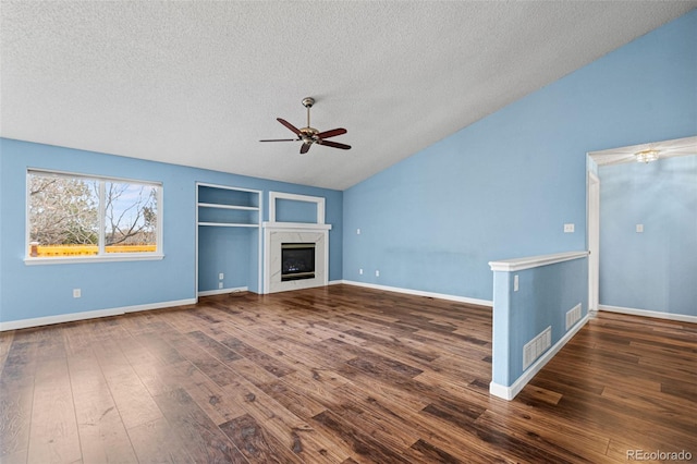 unfurnished living room with vaulted ceiling, a premium fireplace, built in features, and dark hardwood / wood-style floors