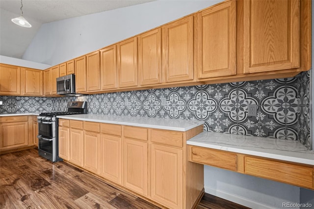 kitchen featuring dark wood-type flooring, backsplash, stainless steel appliances, and vaulted ceiling