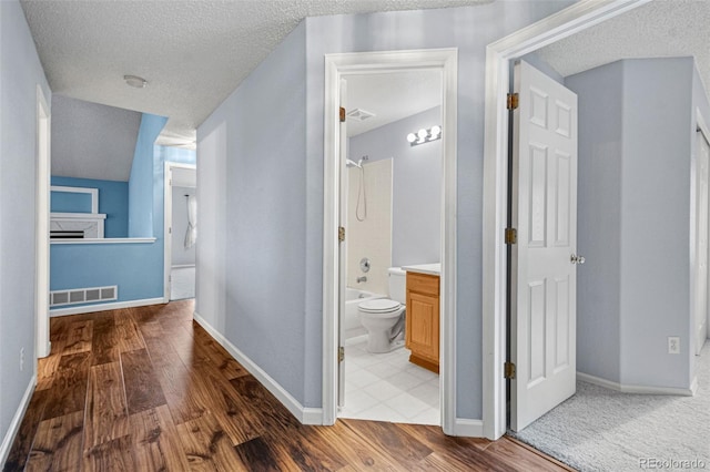 corridor featuring hardwood / wood-style flooring and a textured ceiling