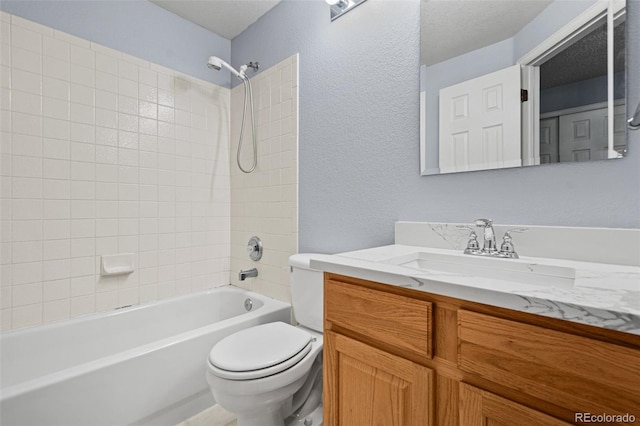 full bathroom featuring toilet, vanity, and tiled shower / bath combo