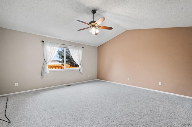 carpeted spare room featuring lofted ceiling, ceiling fan, and a textured ceiling