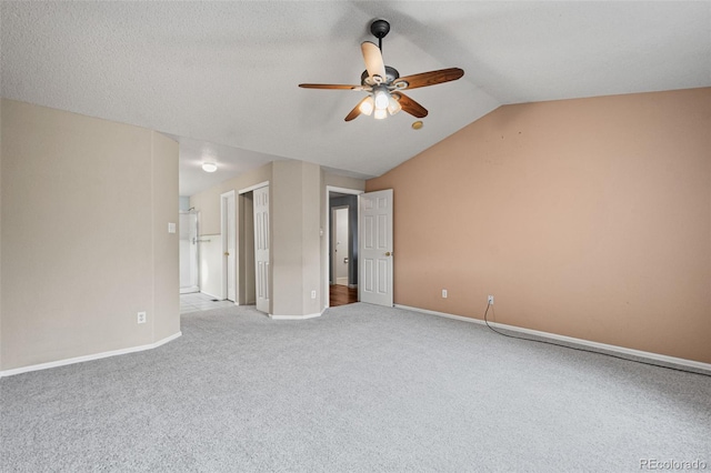 carpeted empty room with vaulted ceiling and ceiling fan