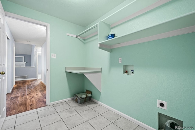 laundry room with washer hookup, light tile patterned floors, and hookup for an electric dryer