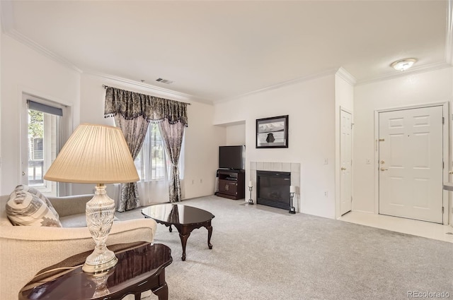 carpeted living room with a tiled fireplace and ornamental molding