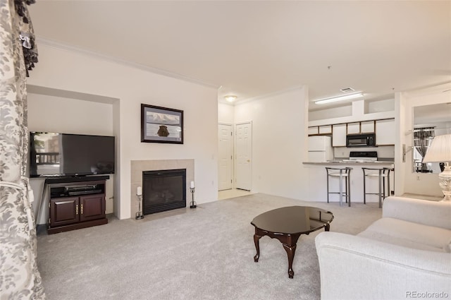 living room with ornamental molding, light carpet, and a tile fireplace