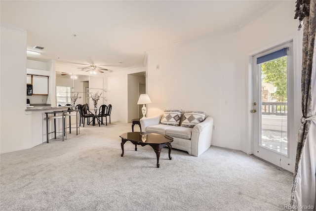 carpeted living room featuring ceiling fan and ornamental molding