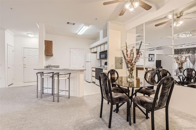 dining space with ornamental molding, light colored carpet, sink, and ceiling fan