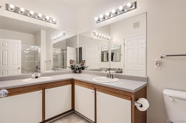 bathroom featuring a shower with door, vanity, and toilet