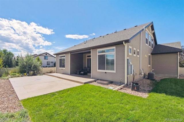 back of property featuring a patio area, a yard, and central AC