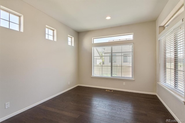 unfurnished room with visible vents, baseboards, dark wood-type flooring, and recessed lighting