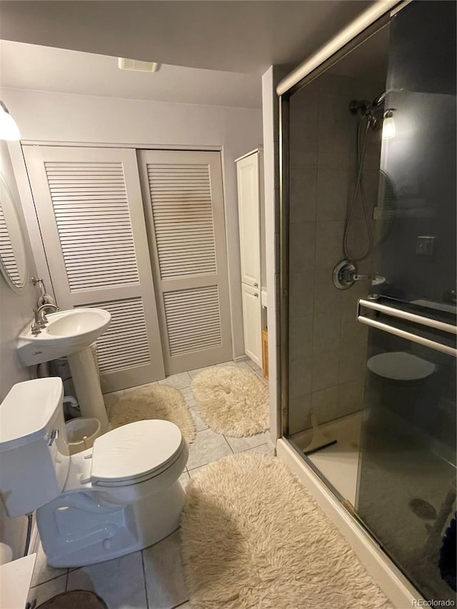 bathroom featuring tile patterned floors, toilet, and walk in shower