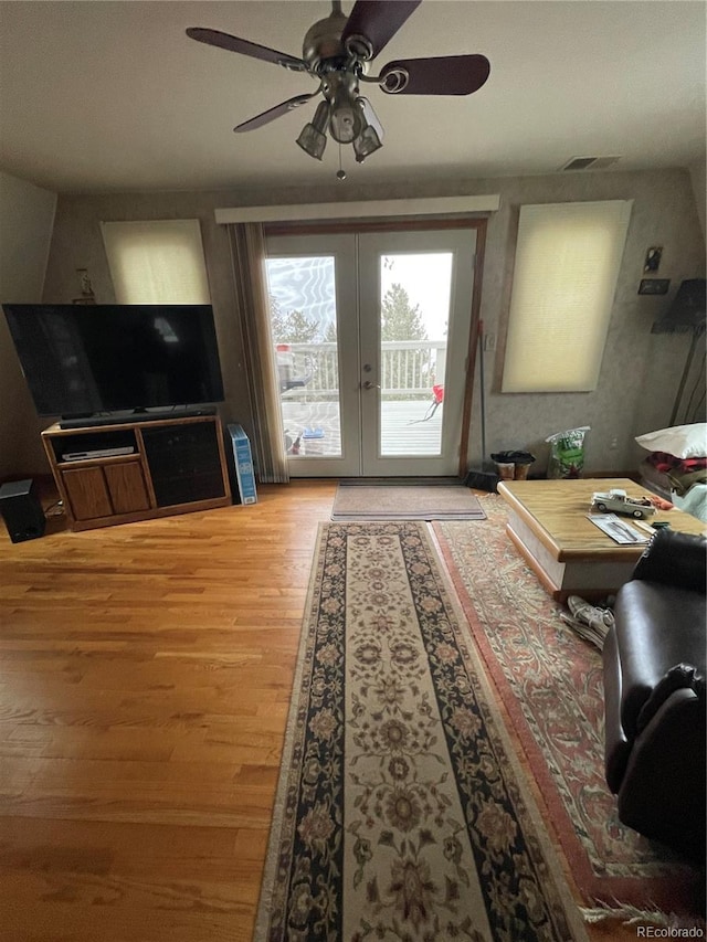 living room with hardwood / wood-style flooring, french doors, and ceiling fan