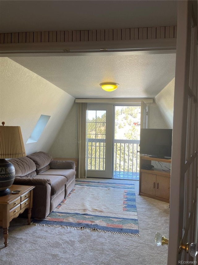 carpeted living room with lofted ceiling and a textured ceiling