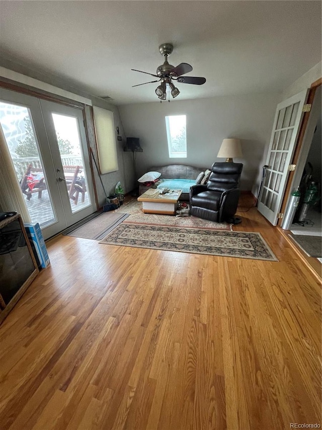 unfurnished living room with ceiling fan, plenty of natural light, french doors, and wood-type flooring