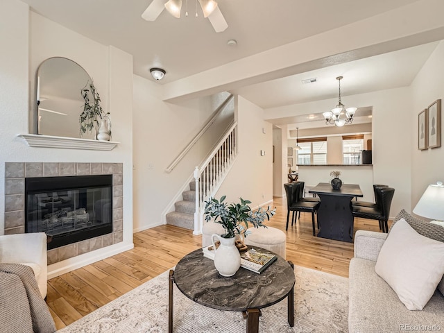 5467 Zephyr Ct Unit 5467, Arvada, CO 80002 - living area with stairway, wood finished floors, a chandelier, ceiling fan, and a tile fireplace