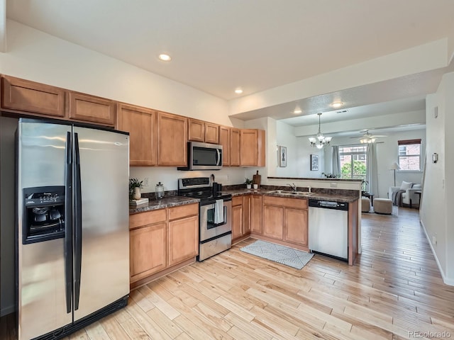 5467 Zephyr Ct Unit 5467, Arvada, CO 80002 - kitchen with stainless steel appliances, a chandelier, a peninsula, a sink, and light wood-style flooring