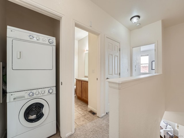 5467 Zephyr Ct Unit 5467, Arvada, CO 80002 - laundry room with stacked washer / drying machine and light tile patterned floors