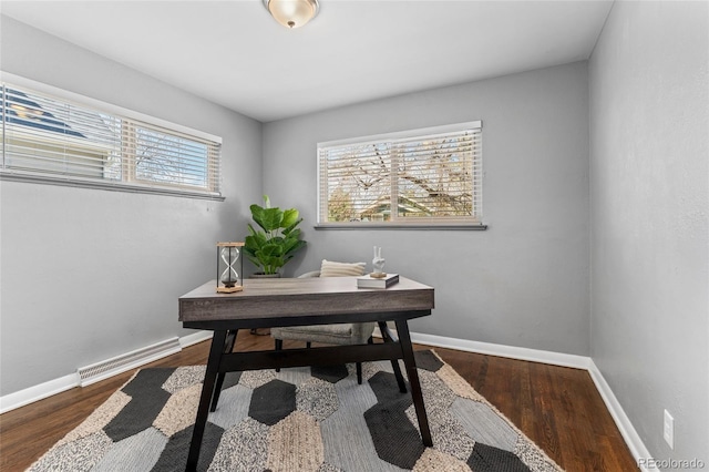 home office with baseboards, wood finished floors, and visible vents