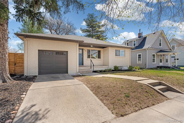 view of front facade featuring a garage, concrete driveway, fence, a front yard, and brick siding