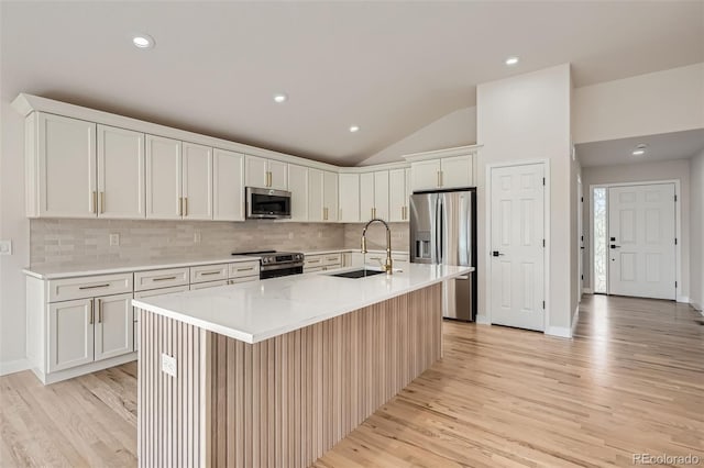15870 Duckweed Ct, Parker, CO 80134 - kitchen featuring a sink, decorative backsplash, light wood-style floors, and stainless steel appliances