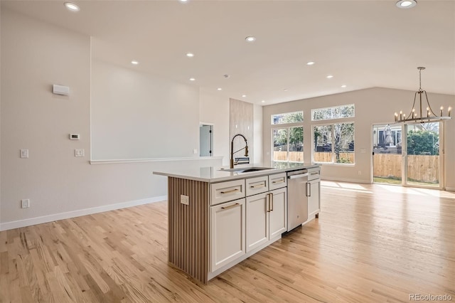 15870 Duckweed Ct, Parker, CO 80134 - kitchen with stainless steel dishwasher, light wood-style floors, open floor plan, a sink, and a notable chandelier