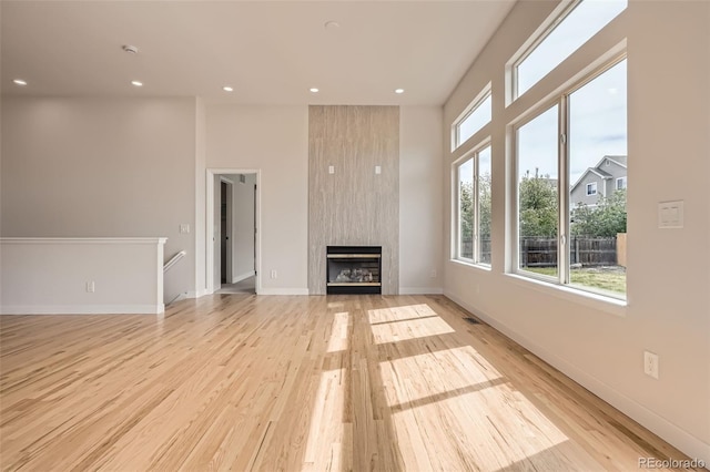 15870 Duckweed Ct, Parker, CO 80134 - unfurnished living room featuring recessed lighting, light wood finished floors, baseboards, and a large fireplace